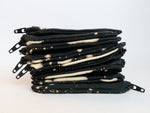 Stack of black zipper pouches with bleach dye pattern